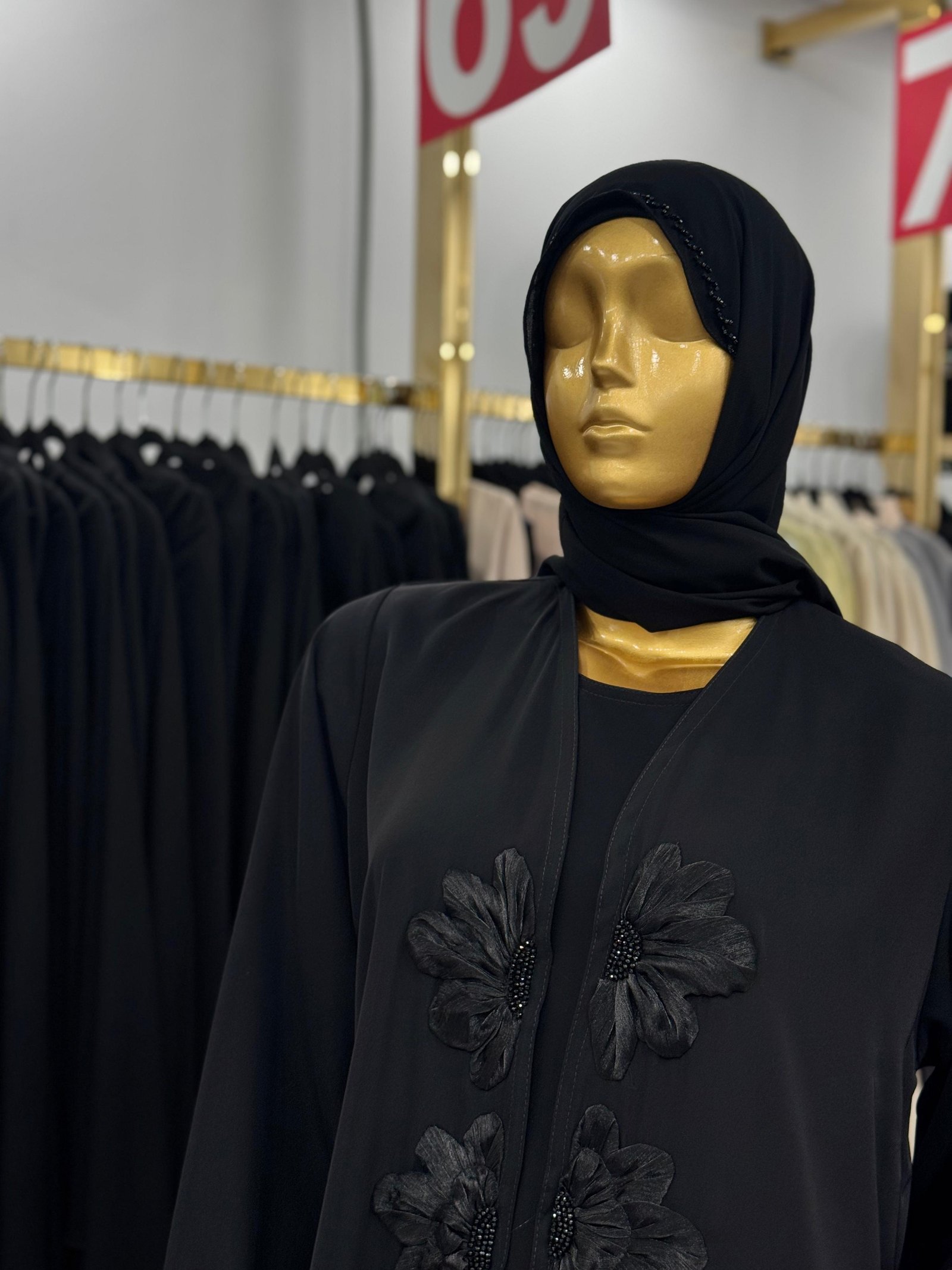 مانيكان يعرض عباية داكنة داخل المتجر