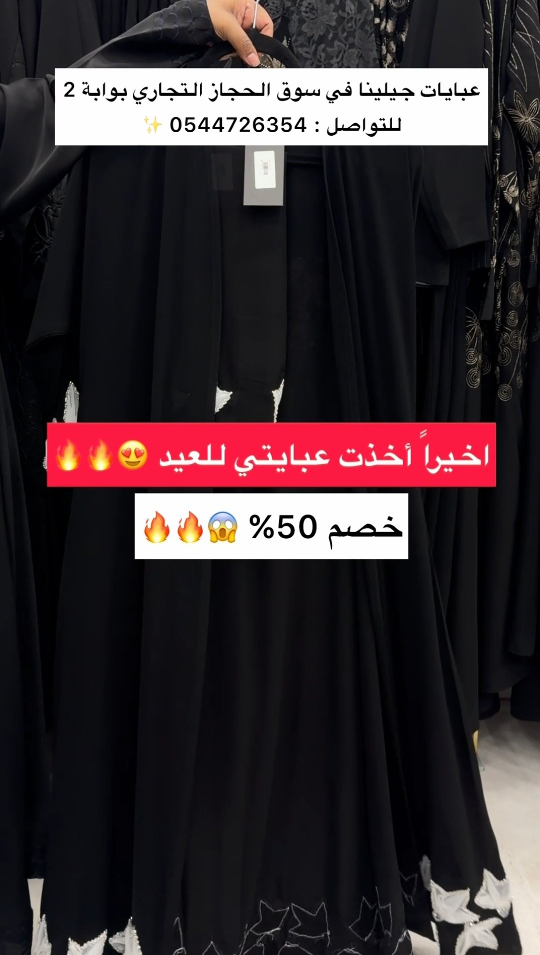 عارضة ترتدي عباية داكنة بتفاصيل مطرزة على الواجهة