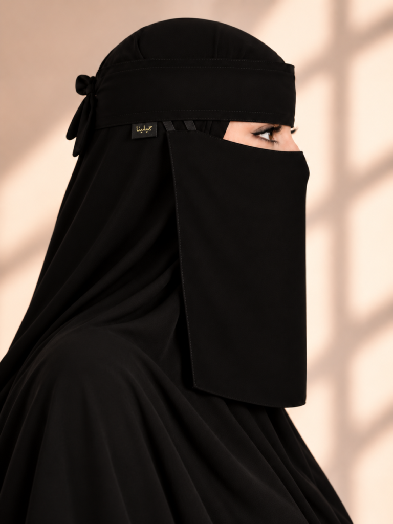 نقاب مطاطين أسود من عبايات جيلينا، منظر جانبي باتجاه اليمين يظهر شريطي المطاط المنفصلين وشريط الجبين العريض وعلامة جيلينا الذهبية